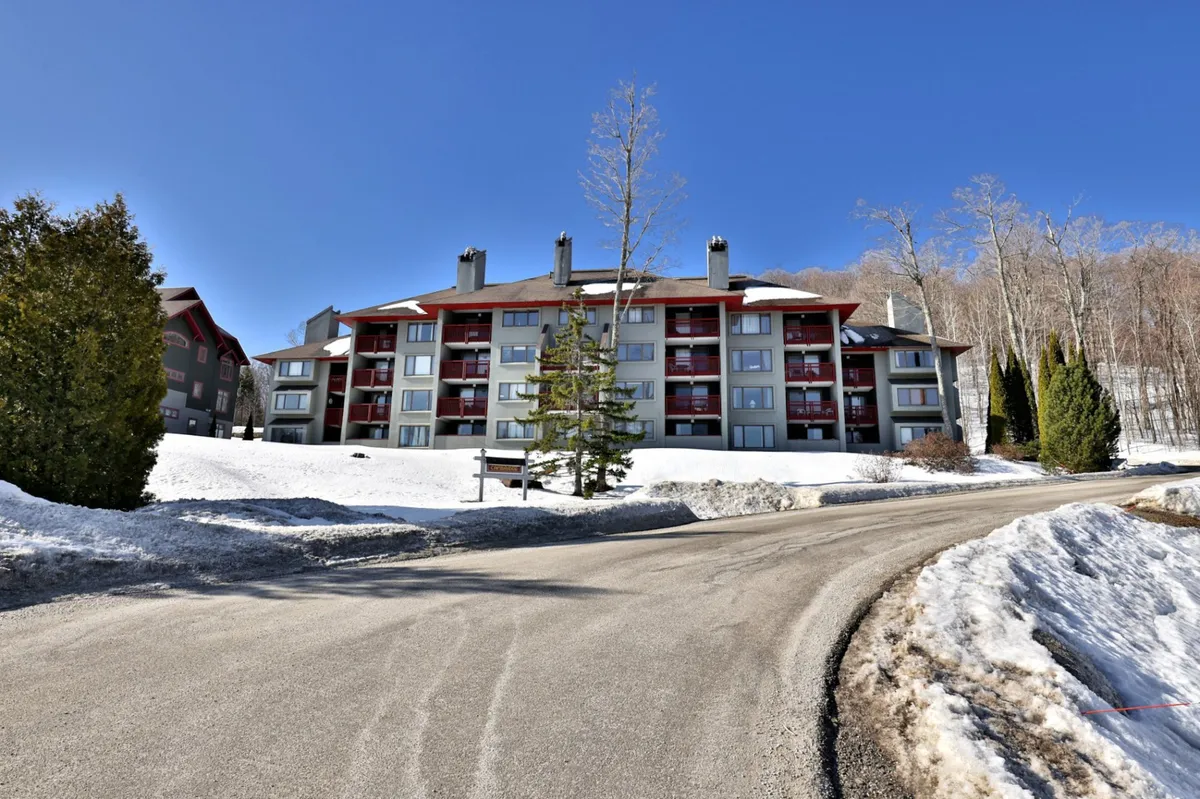 An exterior shot featuring the building set against a serene, snowy landscape with surrounding trees. The calm, peaceful setting suggests tranquility and opportunities for outdoor wellness activities like nature walks or simply relaxing outdoors.